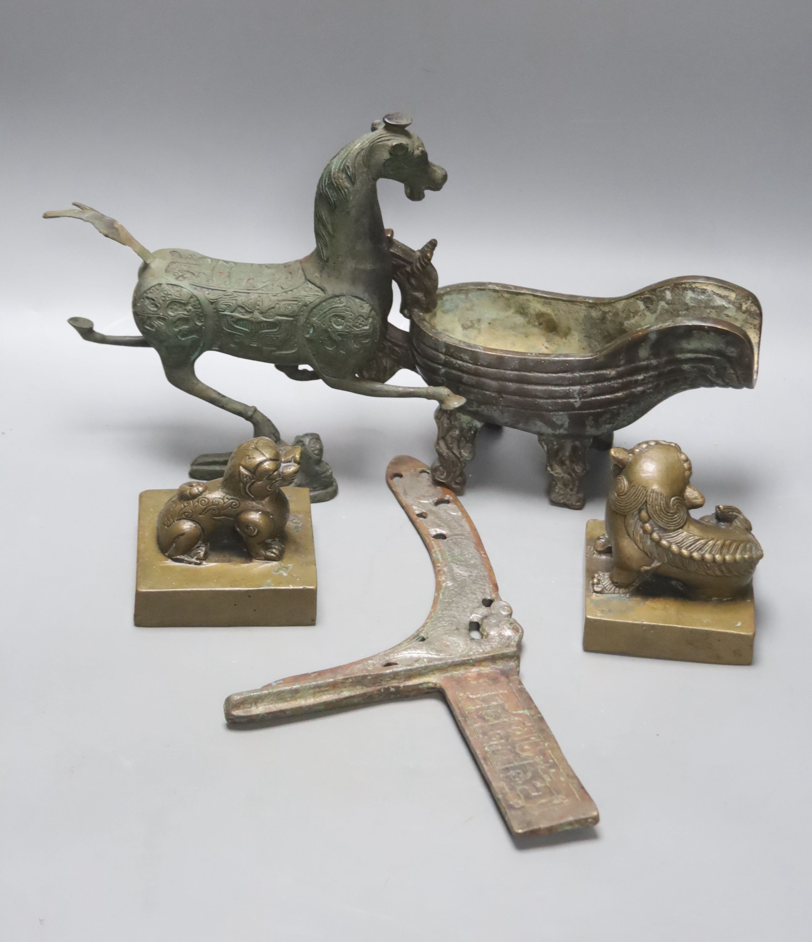 A group of Chinese archaistic bronzes, to include a pouring vessel, two ‘mythical beast seals’, a prancing horse figure and a spearhead